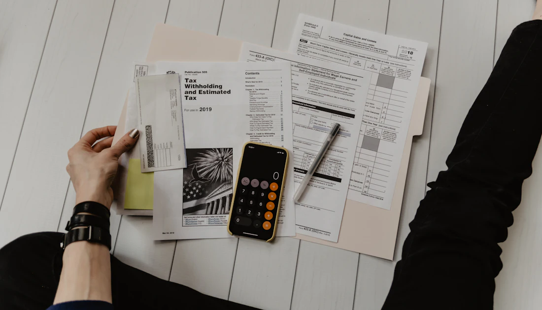 Accountant working through client documents with a calculator